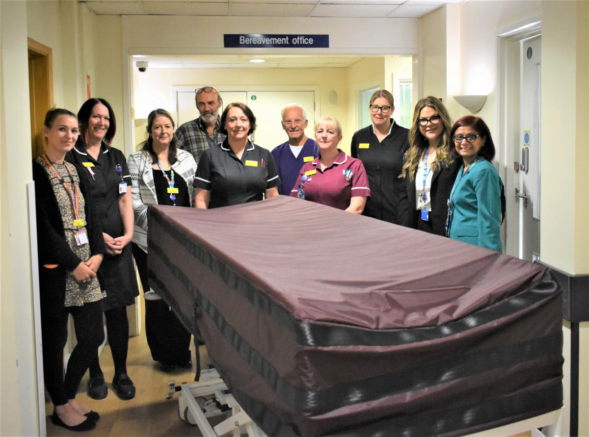 Team standing with end of life trolley